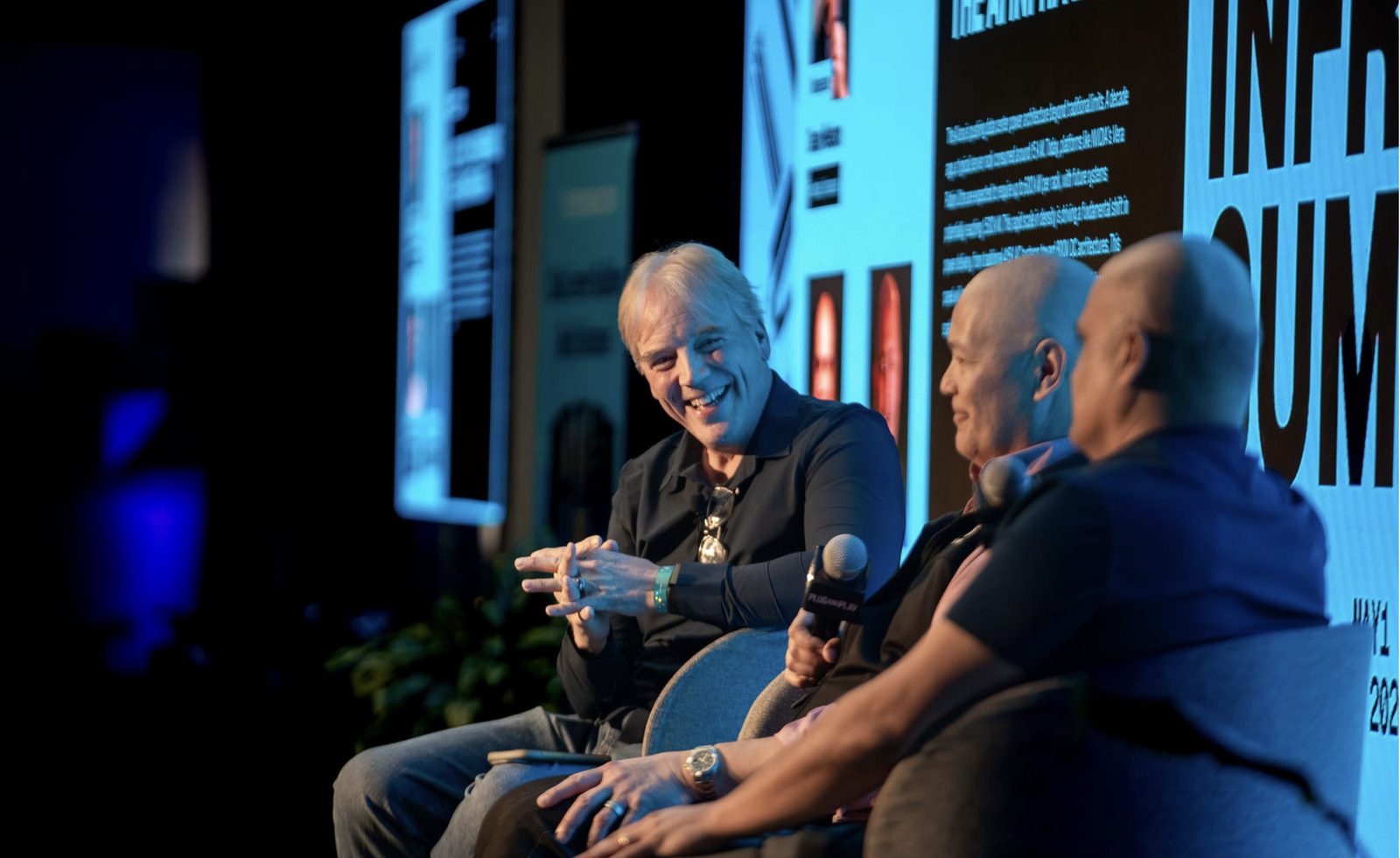 Three panelists sharing a laugh on stage at an IgniteGTM event