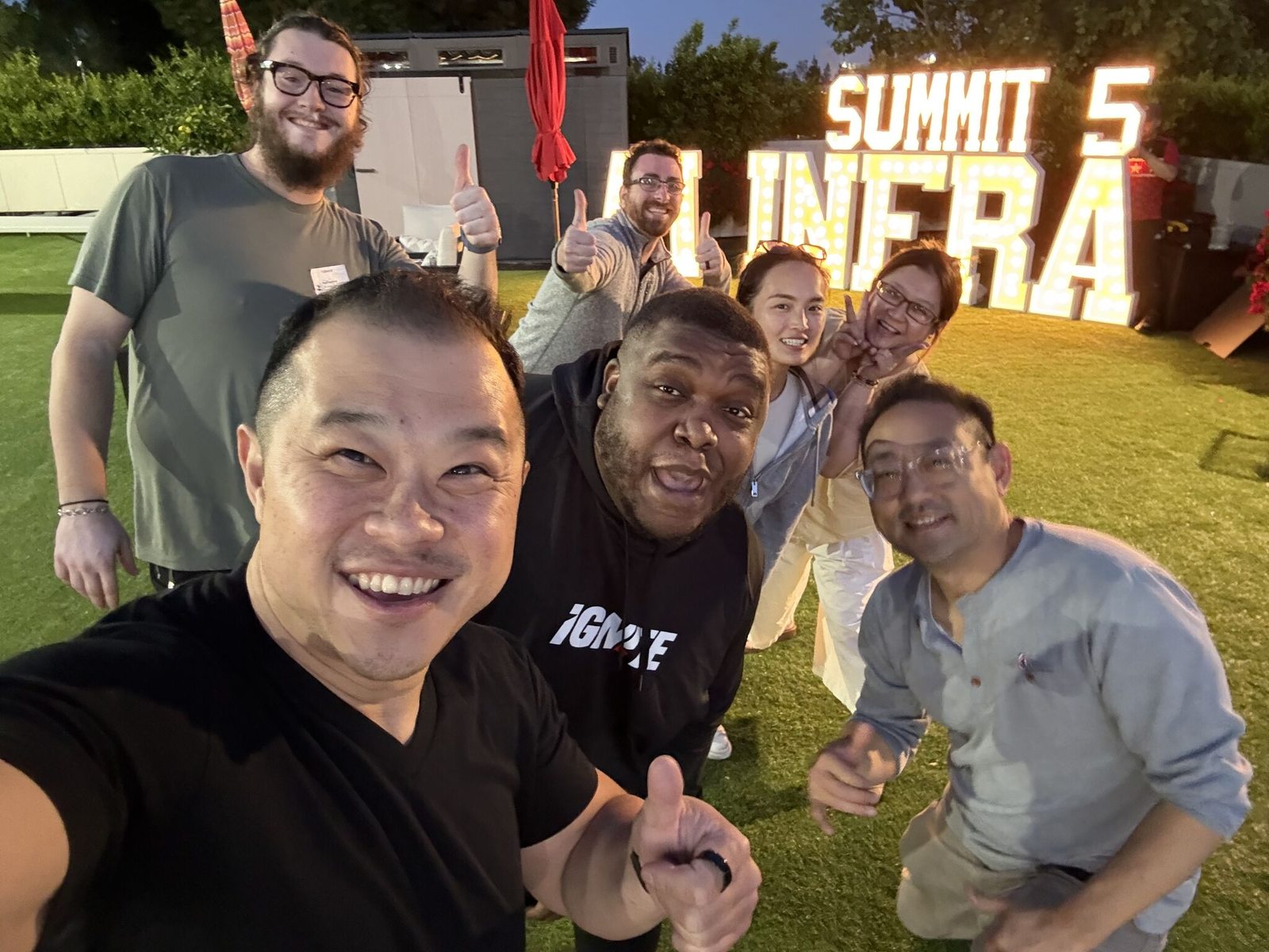 The IgniteGTM team celebrating in front of the lit Summit 5 marquee at golden hour